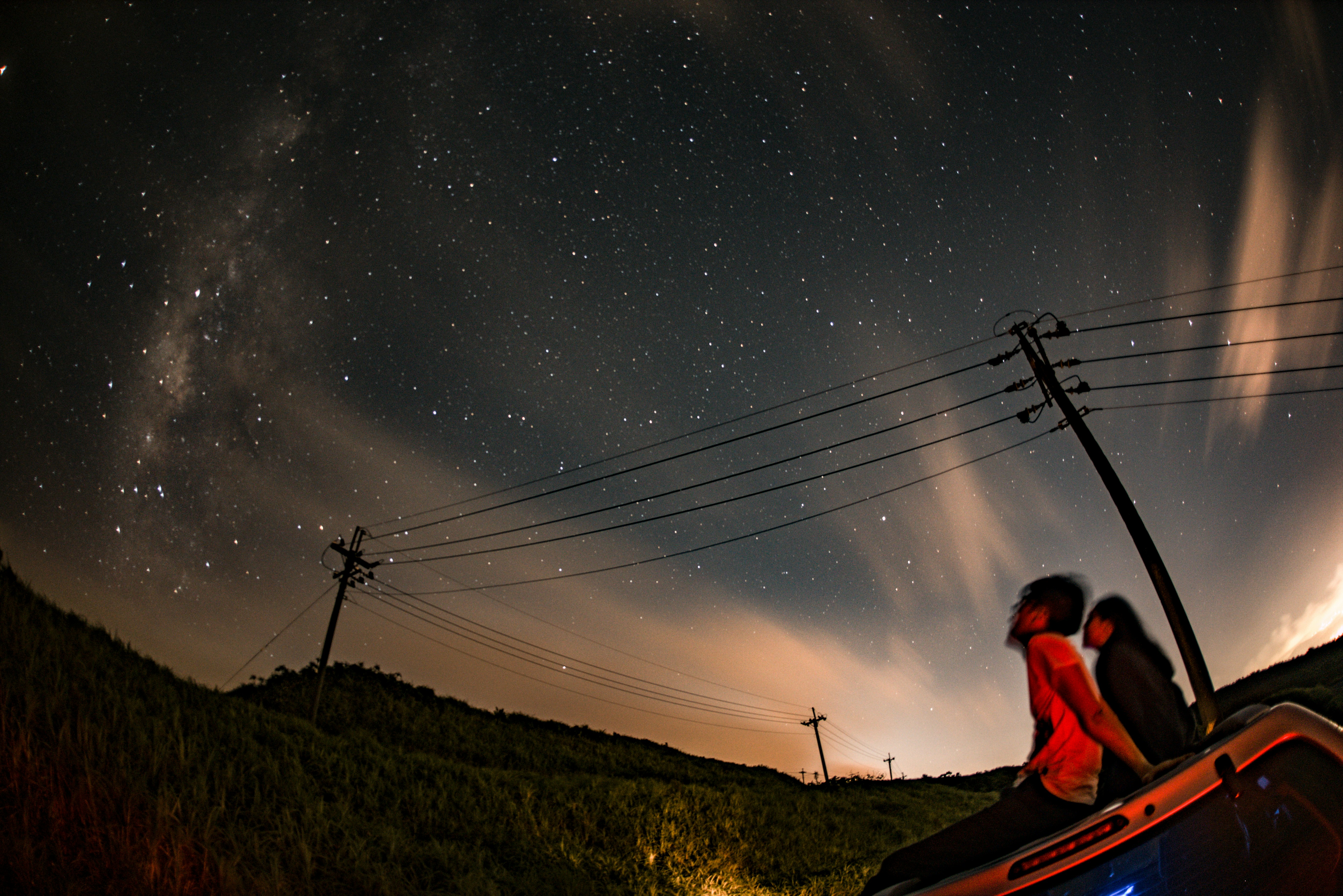 man and woman sitting on vehicle roof